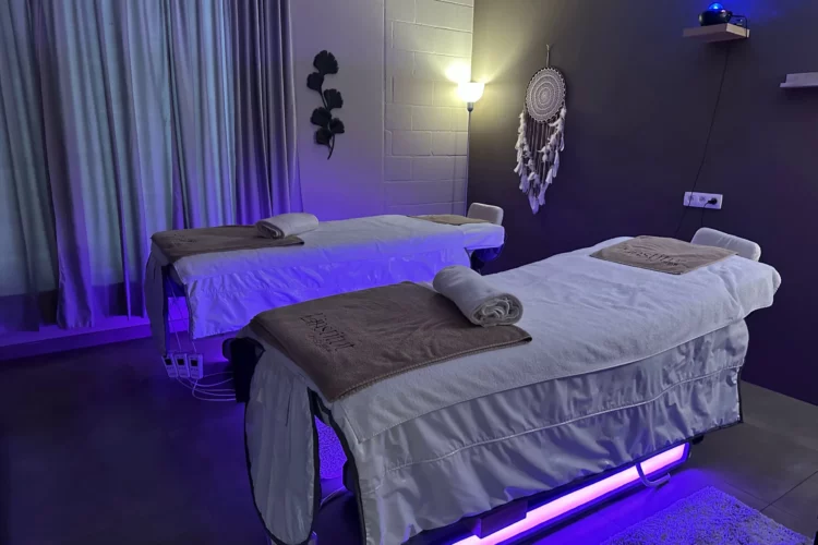 Cabine de soin duo élégante avec deux tables de massage prêtes pour un soin en couple à l'Institut By Scarlett, Braine-l'Alleud.